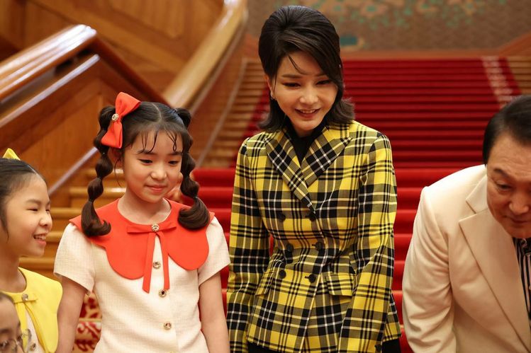 김건희 여사가 지난 5월 22일 청와대 대정원 야외무대에서 열린 청와대 국민개방기념 열린음악회가 끝난 뒤 청와대 본관에서 음악회에 출연한 합창단원들과 기념촬영을 하고 있다. 이날 김 여사는 작정한 듯 패턴이 분명한 명품 브랜드 의상을 입었다.