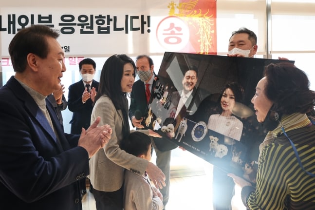 윤석열 대통령과 김건희 여사가 17일 서울 서초구 아크로비스타 사저를 찾아 주민들로부터 사진을 선물받고 있다. /대통령실 제공