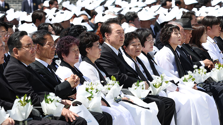 윤석열 대통령과 오월어머니 회원들 등 참석자들이 18일 광주시 북구 국립5·18민주묘지에서 열린 제44주년 5·18민주화운동 기념식에서 '5·18상징꽃'인 이팝나무 꽃다발과 함께 앉아 있다. /대통령실통신사진기자단