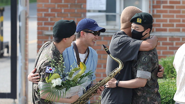 그룹 방탄소년단(BTS)의 진(왼쪽)이 12일 오전 경기도 연천군 육군 5사단 신병교육대대에서 전역하며 RM과 포옹하고 있다. 오른쪽부터 지민, 뷔. /연합뉴스