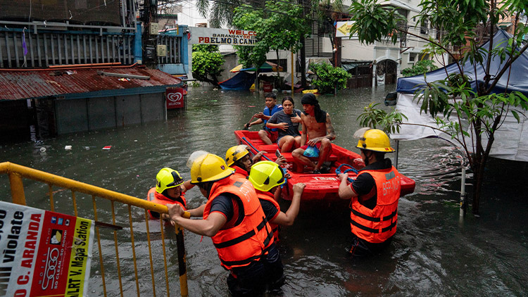 24일 제3호 태풍 '개미'의 영향으로 침수된 필리핀 마닐라 거리를 주민들이 구조대원들의 도움을 받아 보트를 타고 이동하고 있다. 태풍 '개미'는 필리핀 북부 지역에 많은 비를 쏟은 뒤 대만 방향으로 이동하고 있다. /로이터=연합뉴스