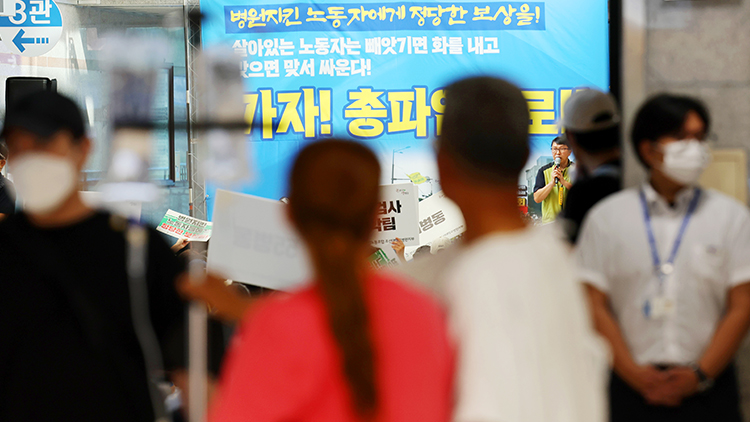 29일 오전 광주 동구 조선대병원 로비에서 환자들이 총파업을 알리는 노조 현수막을 바라보고 있다. /연합뉴스