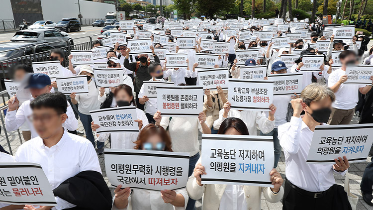 의대교수들이 3일 오후 서울 용산구 대통령실 인근에서 열린 한국의학교육평가원 무력화 저지 결의대회에서 손팻말을 들고 구호를 외치고 있다. /연합뉴스