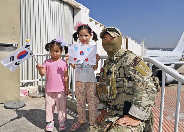 '사랑해요 군인님 우리는 괜찮아요 우리를 구해주러 와서 고맙습니다'라고 적힌 손편지를 건내며 공군 항공특수통제사(CCT)와 기념촬영하고 있는 레바논 교민 자녀들. /공군 제공