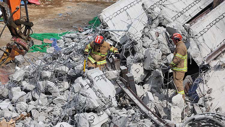 25일 경기도 안성시 서운면 산평리 소재 서울세종고속도로 천안~안성구간 9공구 천용천교 건설 현장에서 교량 연결작업 중 교각에 올려놓았던 상판이 무너지는 사고가 발생해 소방대원들이 인명 수색 구조작업을 하고 있다. /연합뉴스