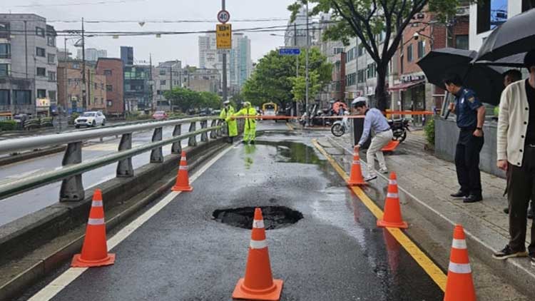 22일 서울 종로구 창신동에서 지름 1m 크기의 땅 꺼짐이 발생해 경찰이 인근 도로의 통행을 통제하고 있다. /연합뉴스 