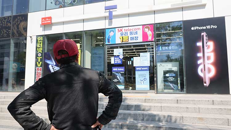 SK텔레콤이 가입자 유심(USIM) 정보 유출 사태로 오는 5일부터 신규 가입자 모집을 중단한다고 밝힌 2일 서울 시내의 한 SK텔레콤 대리점 앞에서 한 소비자가 유심 재고 소진 안내문을 한참 바라보고 있다. /연합뉴스 
