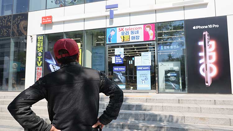 SK텔레콤이 가입자 유심(USIM) 정보 유출 사태로 오는 지난 5일부터 신규 가입자 모집을 중단한다고 밝힌 2일 서울 시내의 한 SK텔레콤 대리점 앞에서 한 소비자가 유심 재고 소진 안내문을 한참 바라보고 있다. /연합뉴스 