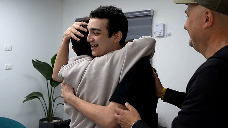 현지시간 12일 이스라엘의 한 장소에서 석방된 이스라엘-미국 국적 인질 에단 알렉산더가 가족과 재회하는 모습 /AFP=연합뉴스