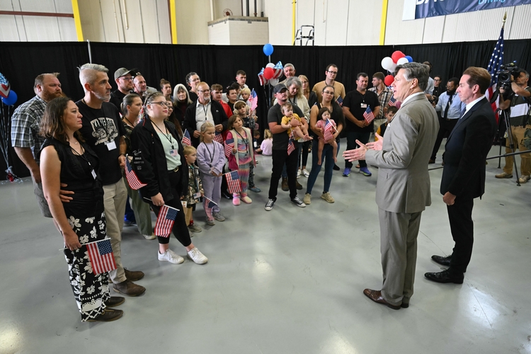 12일(현지시간) 미국 버지니아주 워싱턴 덜레스 국제공항에 도착한 남아프리카공화국 백인들이 미국 정부의 환영 성명을 듣고 있다./AFP