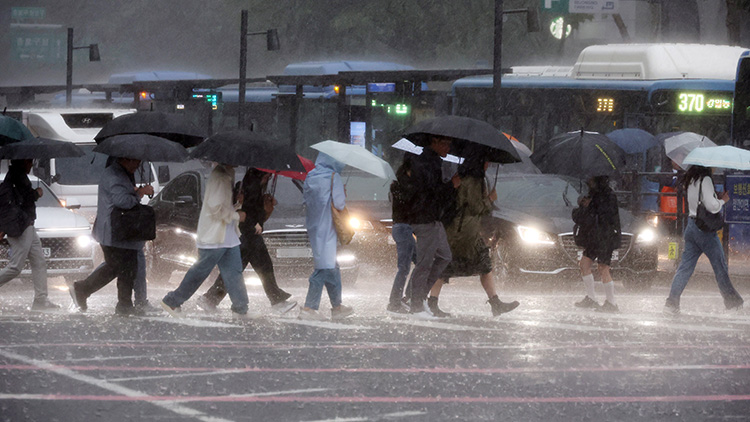 비가 내린 16일 서울 광화문사거리에서 시민들이 우산을 쓴 채 이동하고 있다. /연합뉴스