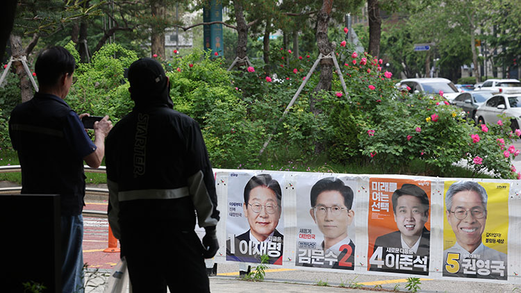 지난 15일 서울 마포구 공덕역 일대에 붙은 제21대 대통령 선거 벽보가 뒤로 장미꽃이 활짝 펴 있다. /연합뉴스 