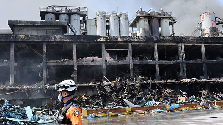 금호타이어 광주공장 화재 발생 이틀째인 18일 소방대원들이 진화 작업을 벌이는 가운데 공장 건물이 검게 타있다. /연합뉴스