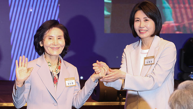 국민의힘 김문수 대선 후보의 부인 설난영 씨와 더불어민주당 이재명 대선 후보의 부인 김혜경 씨가 지난 12일 서울 중구 신라호텔에서 열린 중앙신도회 창립 70주년 기념식에서 손을 맞잡고 있다. /연합뉴스