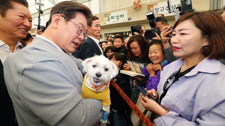 더불어민주당 이재명 대선 후보가 지난 11일 전남 강진군 강진읍 강진오감통시장을 찾아 한 지지자의 반려견을 품에 안고 인사를 하고 있다. /연합뉴스