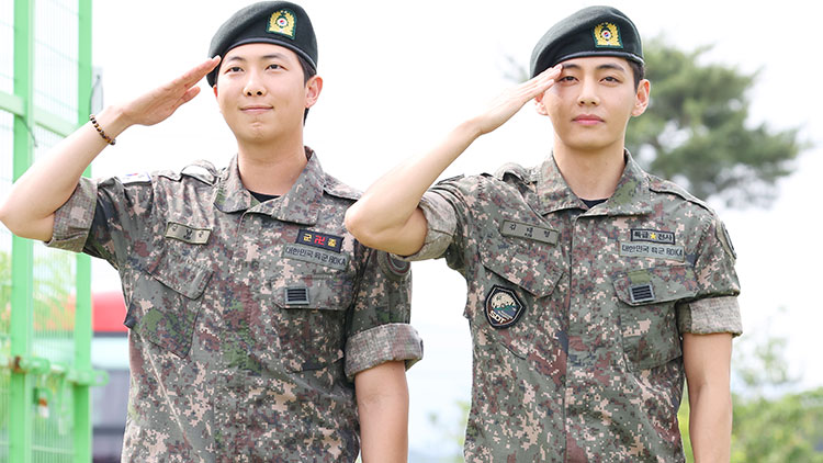 육군 현역 복무를 마치고 만기 전역한 그룹 방탄소년단(BTS) RM과 뷔가 10일 강원 춘천시 신북읍체육공원에서 취재진을 향해 거수경례하고 있다.  /연합뉴스