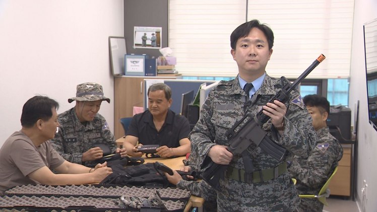 기자가 직접 군복과 모형 소총을 갖추고 일일 시니어 아미 체험을 한 모습