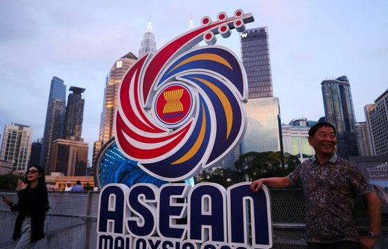 지난 8일(현지시간) 말레이시아 쿠알라룸푸르에서 행인들이 아세안 관련 회의 로고 옆에서 포즈를 취하는 모습. 로이터=연합뉴스