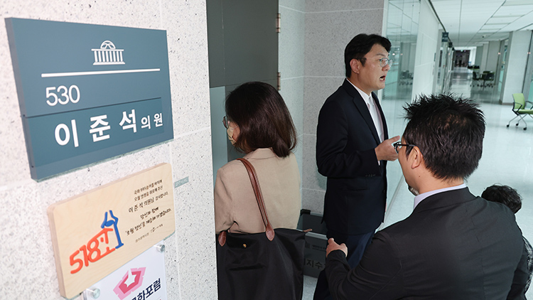 개혁신당 김정철 최고위원이 30일 서울 여의도 국회 의원회관 이준석 의원실 앞에서 '김건희특검 관련 압수수색 절차적 문제점 및 준항고 주요 이유 언론 브리핑'을 하고 있는 가운데 특검 관계자들이 압수수색을 위해 의원실로 들어가고 있다. /연합뉴스 