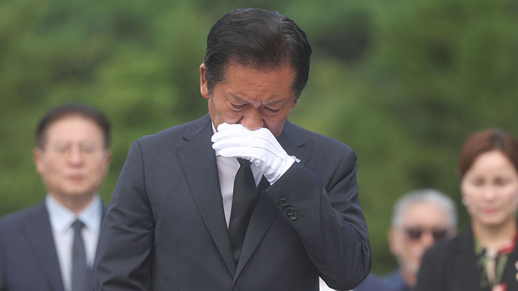 더불어민주당 정청래 대표가 7일 오전 경남 김해시 진영읍 봉하마을을 방문해 노무현 전 대통령 묘역을 참배 후 손으로 얼굴을 닦고 있다.  /연합뉴스