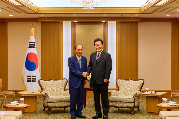 이재명 대통령이 24일 일본 도쿄의 한 호텔에서 일한의원연맹 회장인 스가 요시히데 전 일본 총리를 만나 인사하고 있다.  /공동취재 