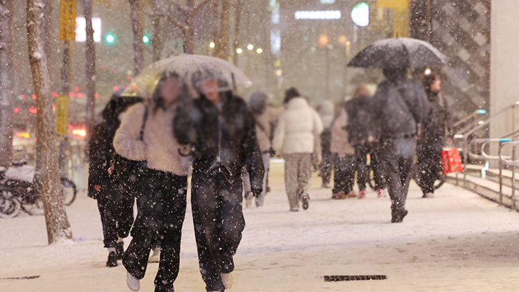 지난 4일 서울 마포구 홍대 부근에 눈이 내리는 가운데 시민들이 이동하고 있다. /연합뉴스