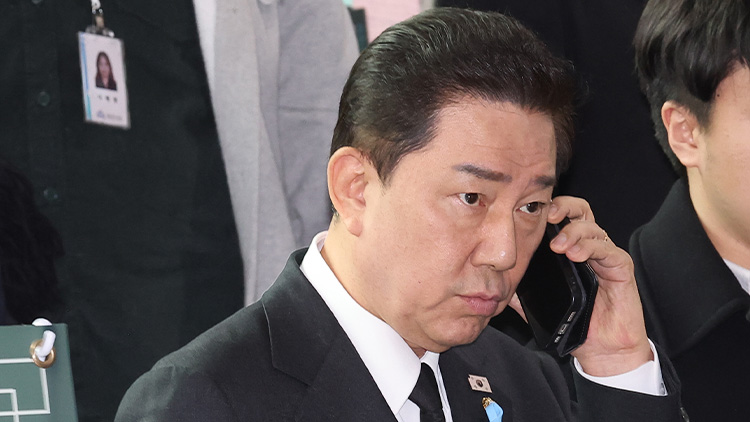 더불어민주당 김병기 원내대표가 29일 전라남도 무안군 무안국제공항 여객터미널에서 열린 12ㆍ29 여객기 참사 1주기 추모식을 마친 뒤 이동하며 전화 통화를 하고 있다. /연합뉴스