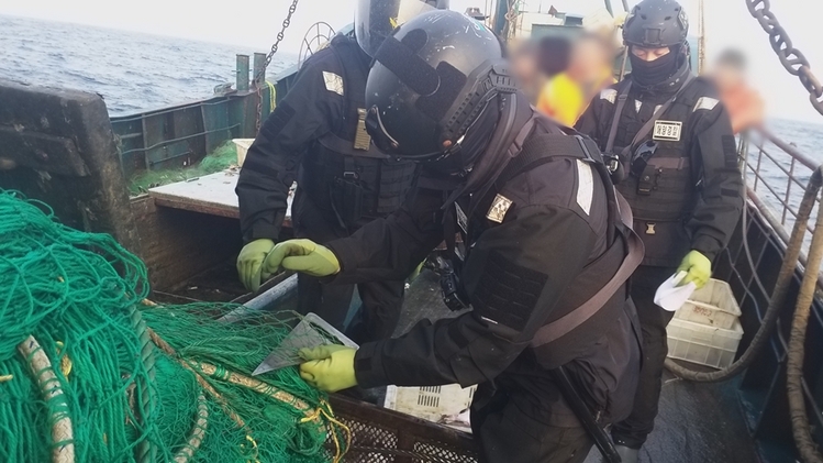 해경이 단속에 적발된 중국어선의 그물코 길이를 재고 있다. 군산해양경찰서 제공