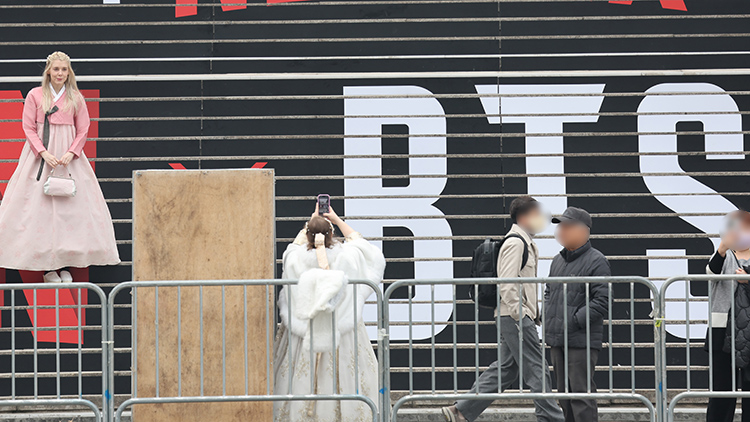 방탄소년단(BTS) 컴백 공연이 닷새 앞으로 다가온 16일 세종문화회관 계단에서 외국인 관광객들이 방탄소년단(BTS) 홍보물을 기념촬영하고 있다. /연합뉴스
