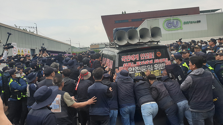 20일 오후 경남 진주시 정촌면 BGF로지스 진주센터에서 화물연대 관계자가 센터 입구로 진입하려는 과정에서 경찰과 대치하고 있다. /연합뉴스 