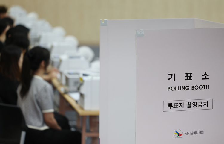 6·3 지방선거 사전투표를 하루 앞둔 28일 울산시 남구청 대강당에 마련된 사전투표소에 투표사무원들이 모의 투표를 하며 장비를 점검하고 있다. /연합뉴스 