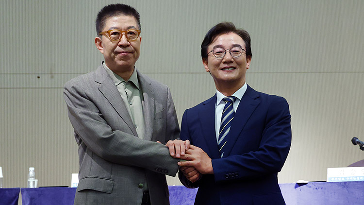 더불어민주당 전재수 부산시장 후보와 국민의힘 박형준 부산시장 후보가 지난달 26일 오전 부산 해운대구 동서대학교 센텀캠퍼스에서 열린 관훈클럽·부산일보 주최 관훈토론회에서 손을 맞잡고 있다. /연합뉴스