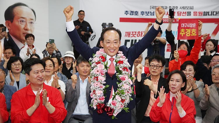 국민의힘 추경호 대구시장 후보가 당선이 유력시되면서 4일 오전 대구 범어네거리 선거사무소에서 축하 꽃다발을 목에 걸고 있다./연합뉴스