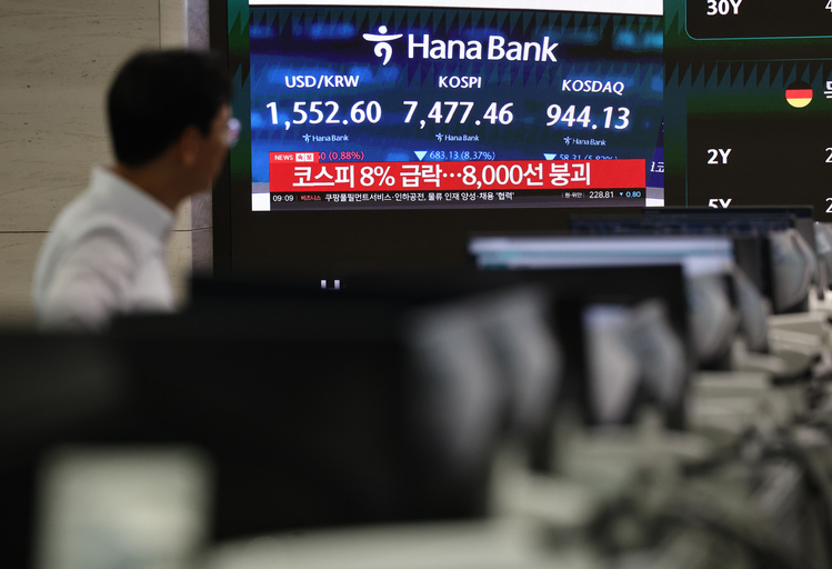 급락장에 코스피 서킷 브레이커가 발동된 8일 서울 하나은행 본점 딜링룸에서 관계자가 관련 방송을 보고 있다. /연합뉴스 