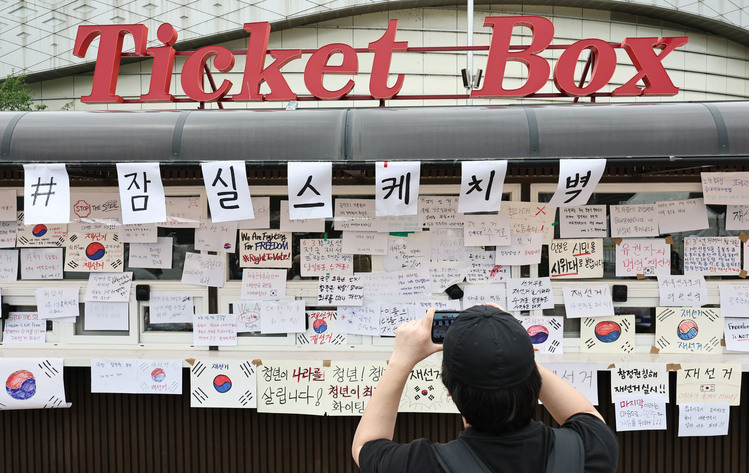 6·3 지방선거 투표지 부족 사태를 규탄하며 재선거를 요구하는 '잠실 개표소 봉쇄 시위'가 계속되고 있는 7일 서울 송파구 올림픽공원 핸드볼경기장 앞 매표소 부스에 재선거를 요구하는 문구 등이 적힌 종이가 붙어있다. /연합뉴스